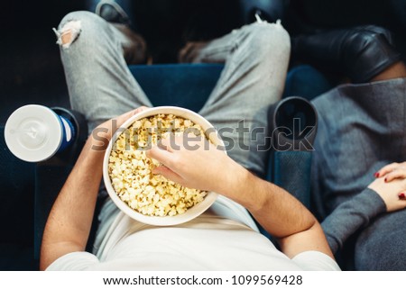 Male person with popcorn in cinema, top view