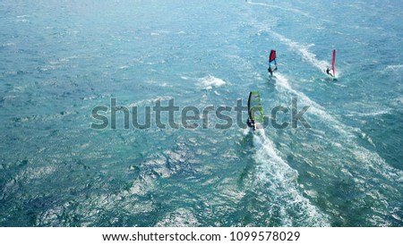 Aerial drone bird's eye view photo of competition surf race in wavy clear waters of Athenian riviera, Vouliagmeni, Attica