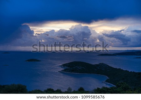 Beautiful nature and landscape photo of stormy sky at dusk evening in Croatia. Nice blue color in Adriatic Sea and the clouds. Scenic outdoors image at Dalmatia coast line. Islands and horizon. 