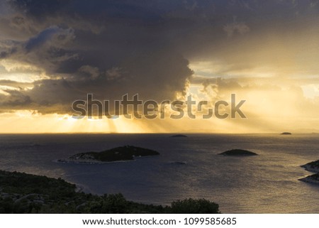 Beautiful nature and landscape photo of stormy sky at sunset evening in Croatia. Nice color in Adriatic Sea and the clouds. Scenic outdoors image at Dalmatia coast line. Islands, sunrays and horizon. 