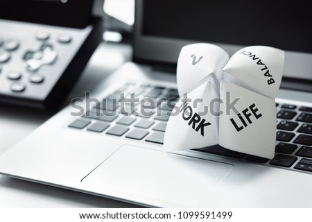 Origami fortune teller on laptop in office concept for work life balance choices Royalty-Free Stock Photo #1099591499