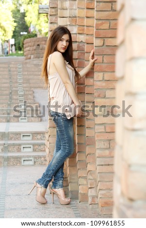 Outdoors fashion portrait of beautiful young brunette girl