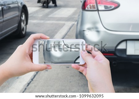 Hand using mobile smart phone taking photo of the car crash accident damage for insurance