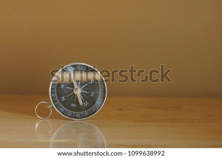 Compass on wooden table background with warm light in morning