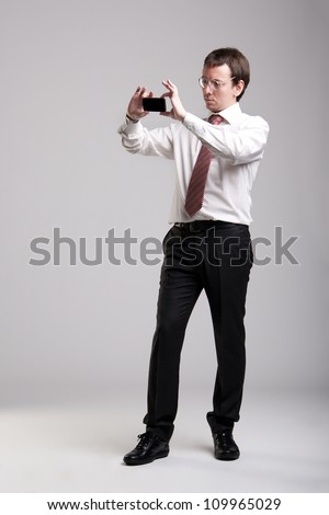 Nerdy manager taking pictures with his smartphone Royalty-Free Stock Photo #109965029