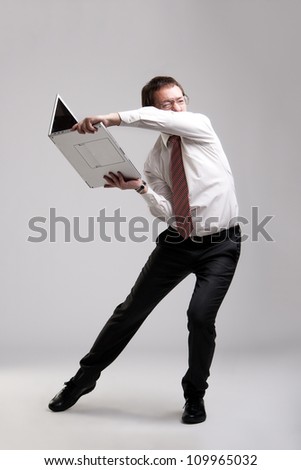Nervous manager trying to break his laptop Royalty-Free Stock Photo #109965032