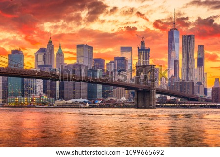 New York, New York, USA skyline of Manhattan on the East River with Brooklyn Bridge after sunset.