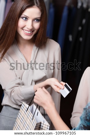 Attractive woman pays with credit card at the store