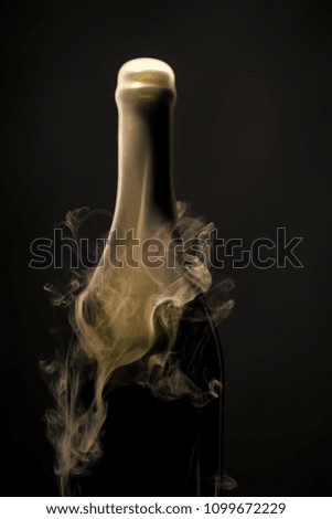 new open full champagme wive sweet or dry drink green glass bottle with beautiful white smoke for celebration christmas or new year in studio on black background, vertical picture
