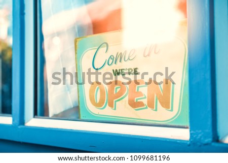 Open sign broad through the glass of door in cafe. Business service and food concept. Vintage tone filter effect color style.