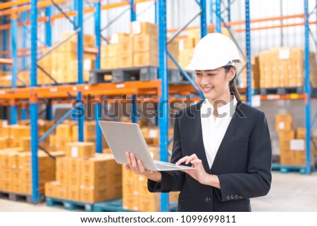Female architect holding laptop with smiling at warehouse. People working concept.