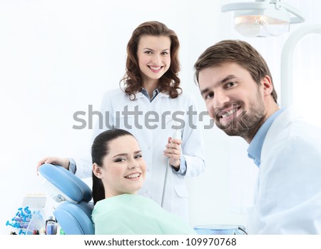 Dentist, his assistant and the patient are preparing to treat carious teeth