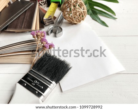 Still life Renovation concept : painting brush and stack of vinyl sample on interior designer desk for creative work space