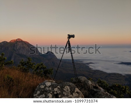 Camera on tripod, outdoors on a mountain at sunrise