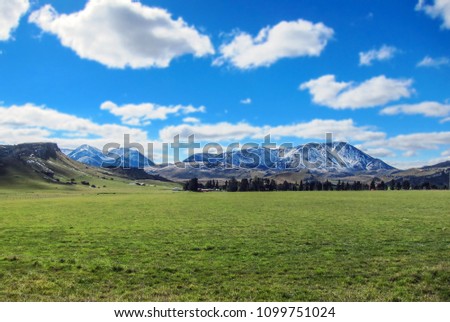 Landscape of field and mountain on cloudy day in New Zealand