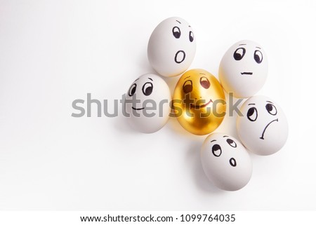 white and one Golden egg with painted faces
