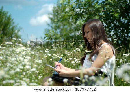 Coquettish brunette in the middle of a field of flowers
