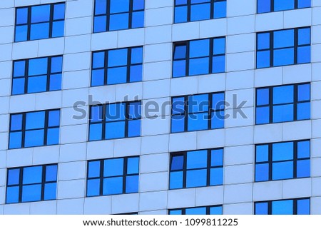 Detail of facade of a building with blue glass windows. Window pattern background.