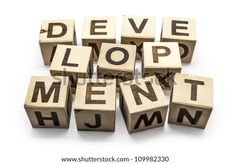 Photo of wooden letter blocks forming the word Development on the white background