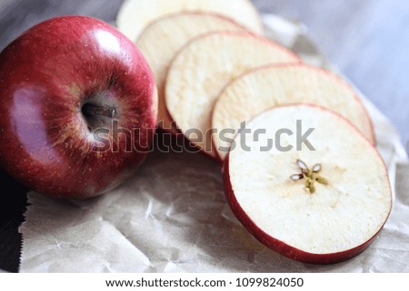 Red fresh apple on a wooden textured kitchen table
