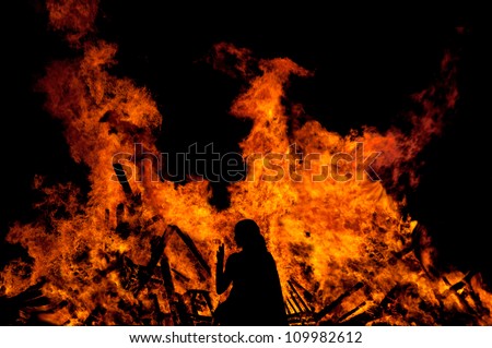 woman standing in front of a big fire