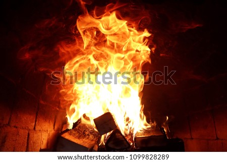 Long tongues of flame of burning fire in a brick oven
