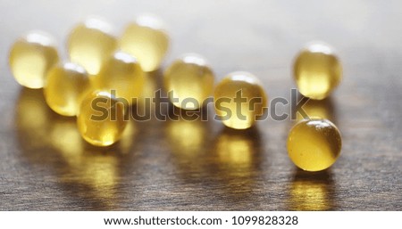 Fish fat. Medical products for the treatment of diseases. The concept of health dependence on tablets. Capsules of fish oil on wooden background.
