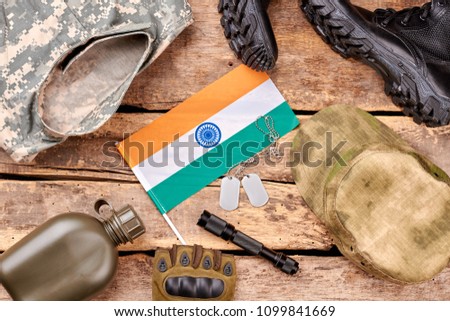 Set of military outfit on wooden background, flat lay. Indian flag, top view.