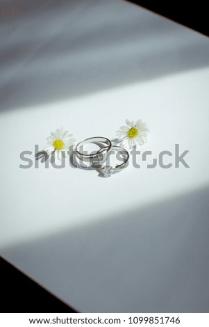 wedding rings and beautiful small  flowers on wooden tabletop
