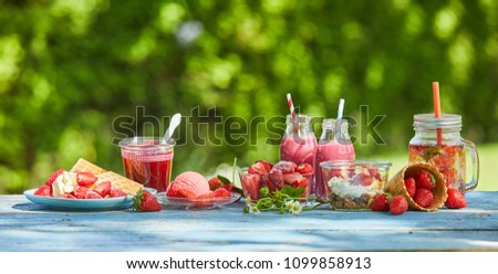 Fresh, healthy, vibrant summer berry smoothie bowls and juices on a bright outdoor table setting.