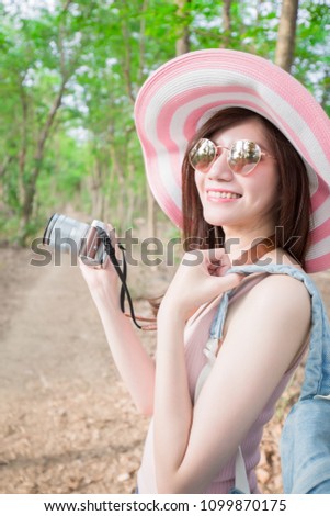 beauty woman take camera and smile happily in the forest