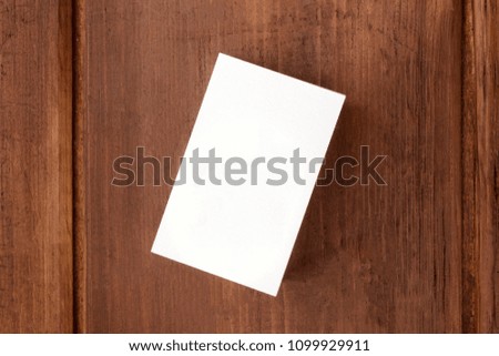 A mockup for a stack of white business cards on a dark background, shot from above, with a place for text