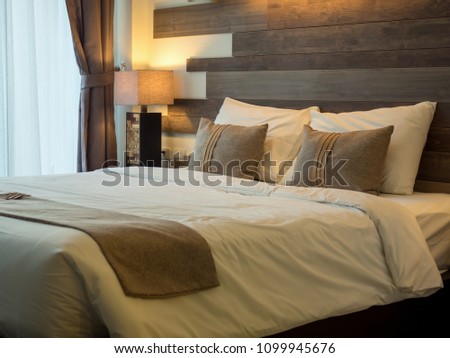 Empty double bed and lamp on side of bed in luxury and natural style bedroom is decorated with wooden boards.
 Royalty-Free Stock Photo #1099945676