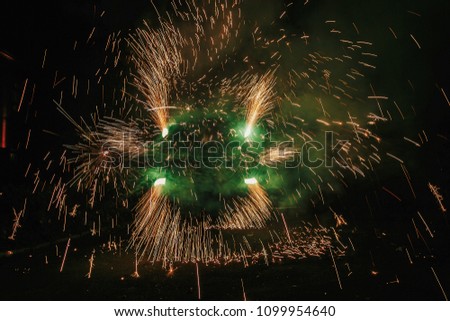 amazing fire show at night at festival or wedding party. Fire dancers swing, spinning green fire and man juggling with bright sparks in the night. fire show performance and entertainment