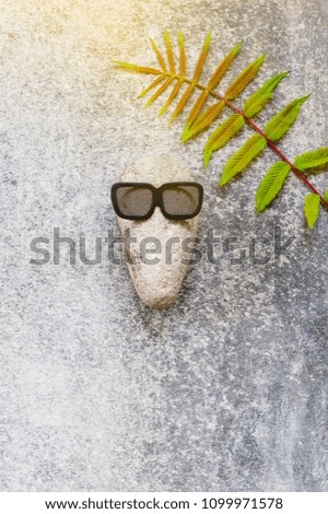 Background with funny character of stones on the grey textured surface, copy space