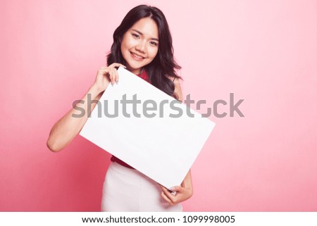 Young Asian woman with white blank sign on pink background