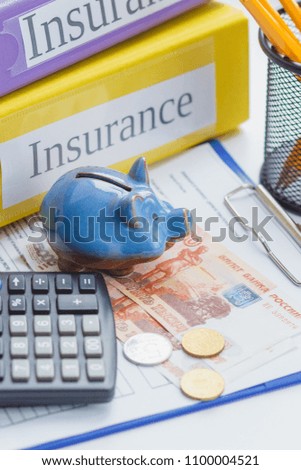 Clean insurance form, piggy bank, calculator and money, soft focus background
