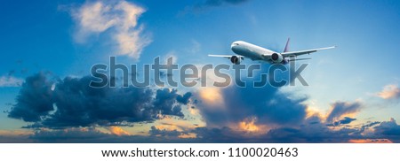 Passenger airplane flying above night clouds and amazing sky at the sunset. Royalty-Free Stock Photo #1100020463