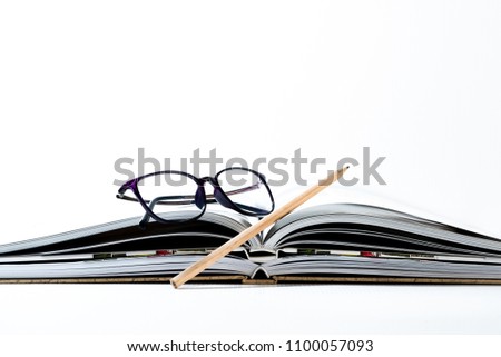  Glasses and pencil on a book and white background