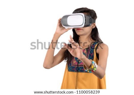 Beautiful girl looking though VR device. Young girl wearing virtual reality goggles headset.