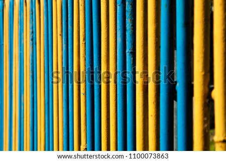 Yellow and blue metal pipe fence