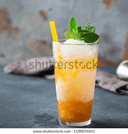 Food and drink, holidays party concept. Cold fresh classic alcohol beverage mint julep cocktail in a highball glass with bourbon, sugar syrup, ice and mint on a table. Dark background
