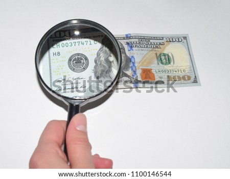 Dollars, notebook and magnifying glass, business theme.