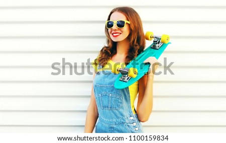 Happyl girl with a skateboard posing over a white background