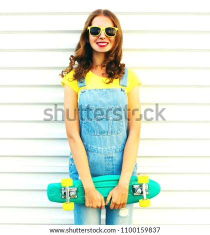 Happy woman with a skateboard posing over a white background