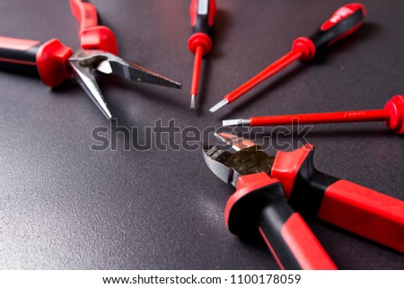 Electrically isolated instrument up to 1000 volts. set of electrician tools on black background. Platypus, screwdriver and wire cutter are lined with fan.