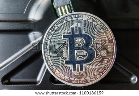 Silver souvenir coin Bitcoin on computer circuit board background.