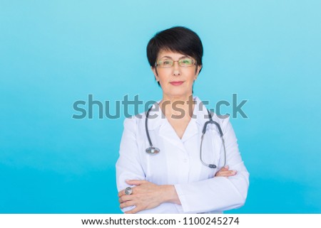 Portrait of female doctor in white coat over blue background
