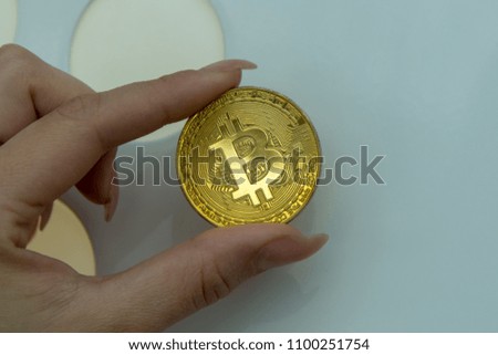  golden bitcoin in woman fingers