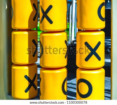 Rotating plastic yellow cylinders with a play of tic-tac-toe for children entertainment